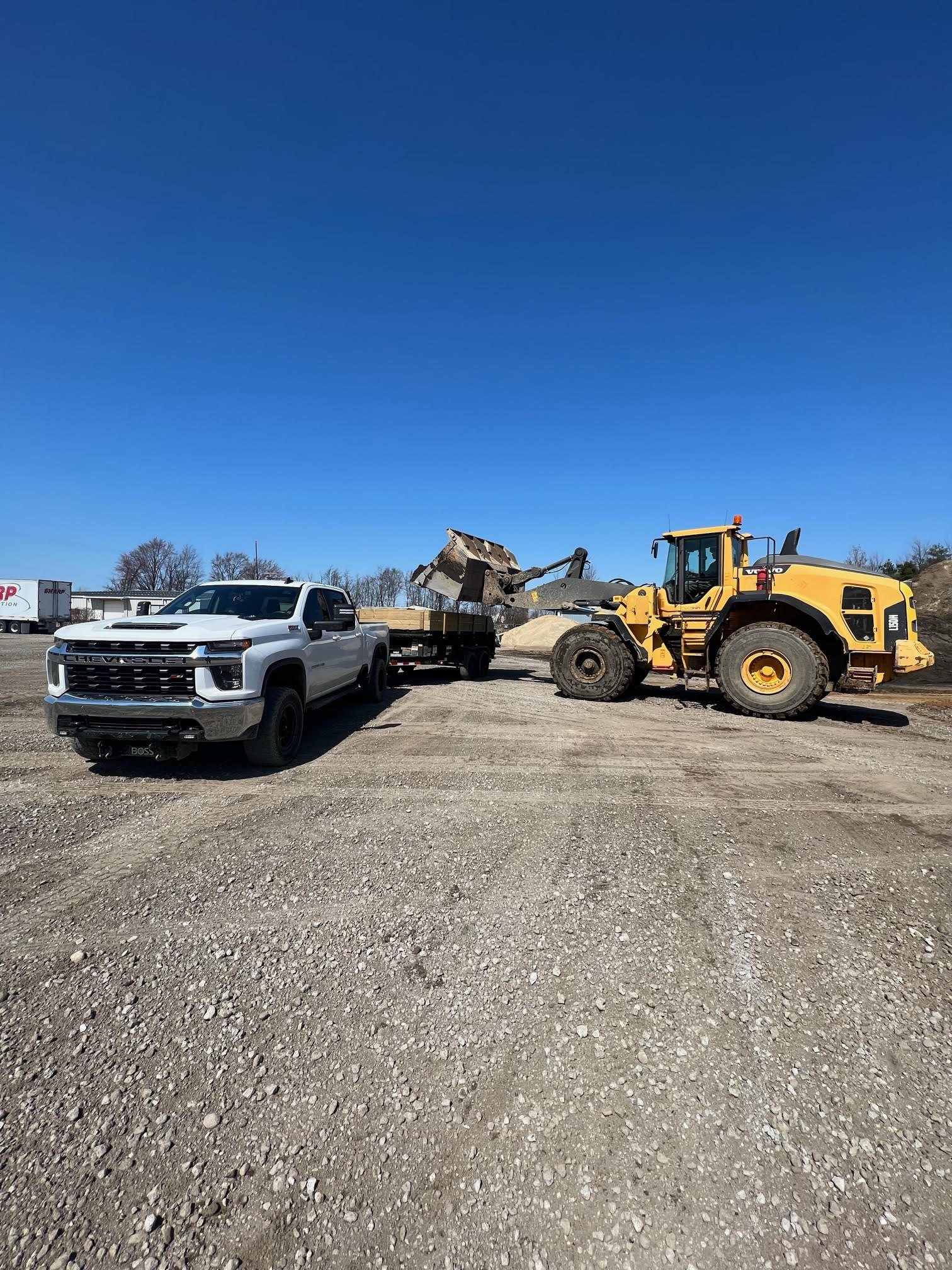 Truck with trailer being loaded with dirt